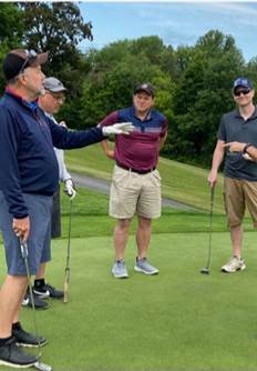 A group of men on a golf course

Description automatically generated