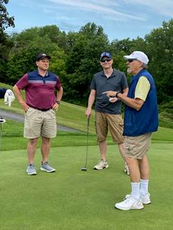 A group of men on a golf course

Description automatically generated